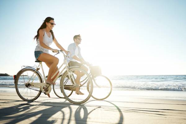 couple riding bikes on the beach