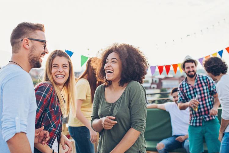 A group of people laugh and enjoy a festival 