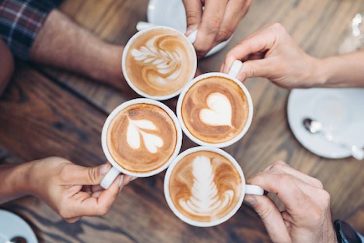 four decorative lattes in the center of a table. shot viewed from above. 