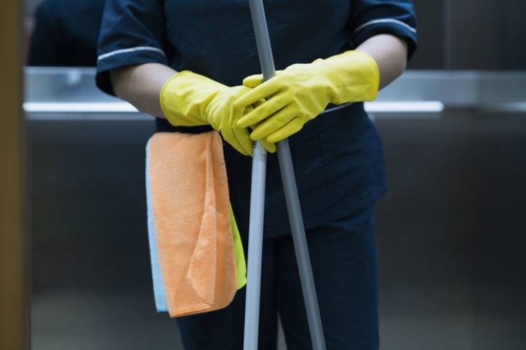 A house cleaner prepares to mop a vacation rental