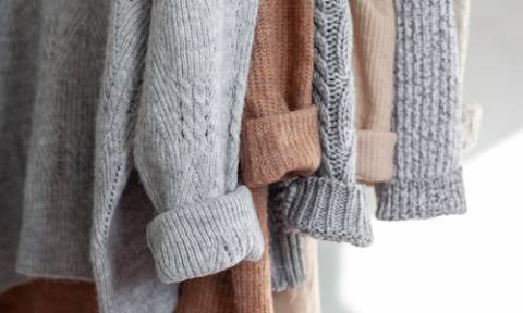 sweaters on a hanging rack